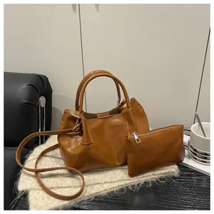 Detailed view of brown faux leather tote bag set including a small pouch and strap