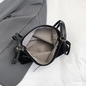 Large black suede tote bag with leather straps and spacious interior for daily commute