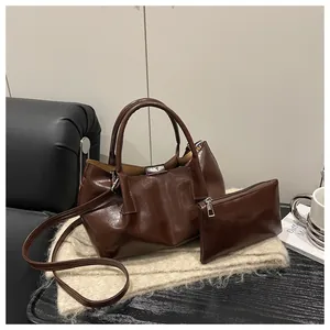 Detail of dark brown polished leather tote bag set with a matching small zipper pouch