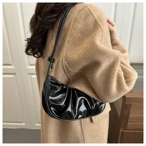 Gros plan d'un sac sous les aisselles plissé noir brillant avec boucle en métal