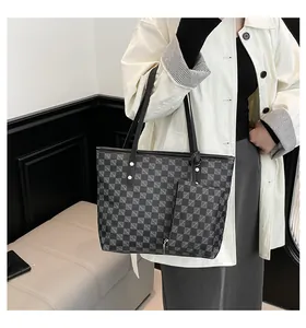 Detalle del conjunto de bolso tote a cuadros con estuche a juego y herrajes de metal