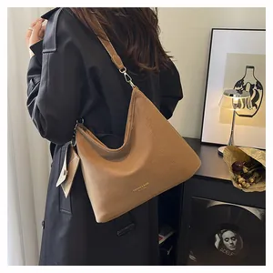 Dettaglio borsa hobo in pelle marrone con stampa e tracolla lunga regolabile