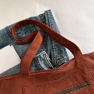 Détail du sac fourre-tout en velours côtelé roux avec coutures et fermeture éclair