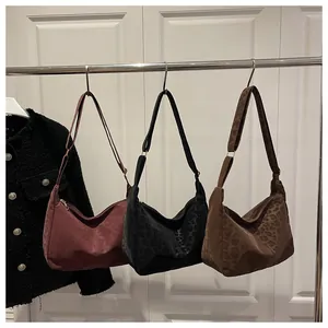 Close-up of leopard pattern hobo bags in burgundy, black, and dark brown on a hanger