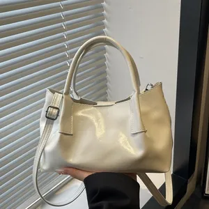 Chic cream white pleated handbag with dual handles and adjustable crossbody strap