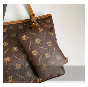 Vue détaillée du sac cabas marron foncé avec motifs trèfles dorés et texture cuir grainé