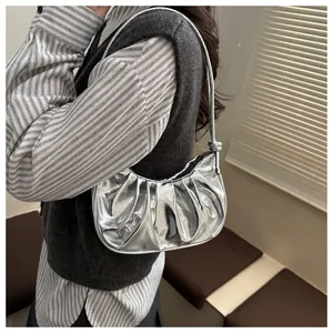Sac à bandoulière argenté métallisé plissé avec détail de nœud porté par un mannequin