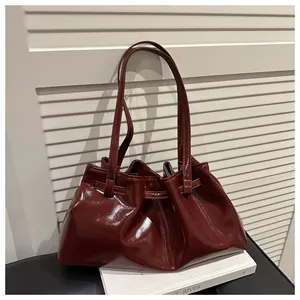 Detail der weinroten, glänzenden Tasche aus Ölwachsleder mit eleganter Faltenstruktur