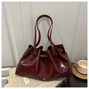 Detail der burgunderroten Lackleder-Schultertasche mit schickem Falten-Cloud-Design