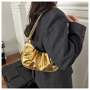 Détail du sac à bandoulière doré métallisé avec texture plissée et sangle à nœud
