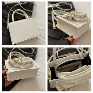 Vue détaillée du sac à main blanc carré en cuir avec nœud de perles et compartiments internes