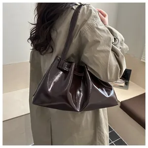 Detail der glänzenden braunen Schultertasche aus Ölwachsleder mit eleganter Faltentextur