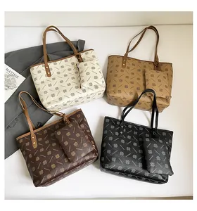 Detailed view of large printed tote bags in four colors with matching smaller pouch charms
