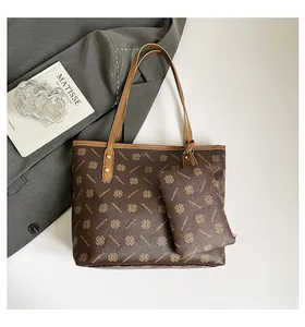 Macro detail of brown tote bag with clover patterns and matching small clutch set