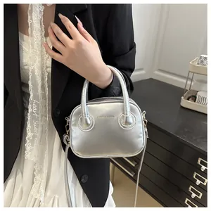 Detailansicht der silbernen Metallic-Tasche mit FASHION & BAGS mit rundem Griffdesign