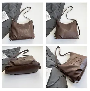 Detail view of coffee brown leather tote bag with embossed GB logo from multiple angles