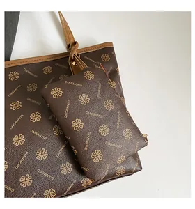 Detail of a brown tote bag and matching pouch set with clover pattern and letter print