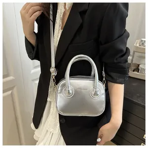 Detail einer silbernen Metallic-Handtasche mit Tragegriff und Fashion & Bags Schriftzug