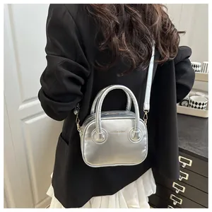 Silberne Metallic-Handtasche an der Schulter mit schwarzem Blazer und weißem Rock