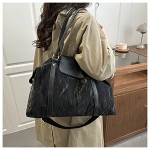 Detail der schwarzen Falt-Reisetasche mit Lederbesatz und verstellbarem Schultergurt