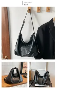 Detail shot of the embossed circular pattern and smooth black PU leather texture of the tote bag