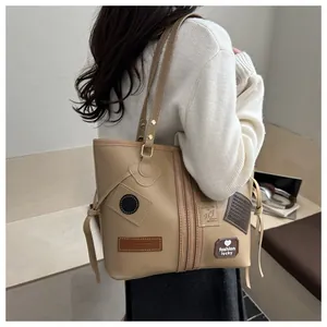 Close-up of khaki PU tote bag with fashion letter patches and double shoulder straps