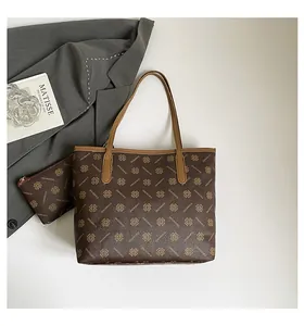 Detail of dark brown tote bag set with clover print and matching small zipper pouch