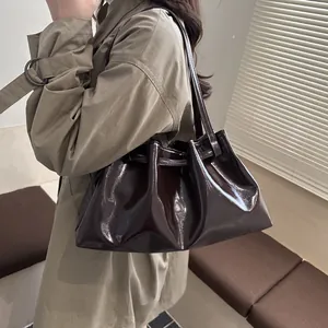 Schicke kaffeebraune Falten-Schultertasche mit Öl-Wachs-Finish getragen von einem Model