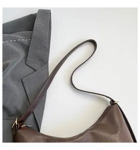 Detailed top view of a dark brown crescent hobo bag with a zipper and smooth leather texture
