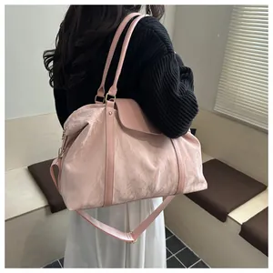 Dettaglio della grande borsa tote rosa pieghettata con tracolla e dettagli dorati