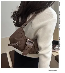 Detail view of large brown canvas shoulder bag with vintage metal buckle and leather strap