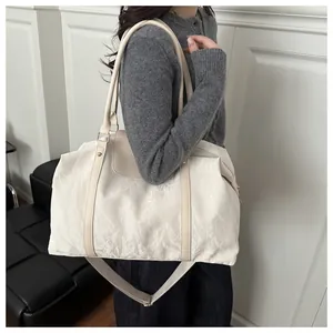 Dettaglio della texture stropicciata bianco crema e della doppia tracolla della grande borsa