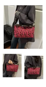 Detail of red leopard and floral print canvas bag with brown leather trim and gold logo
