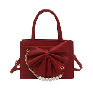 Sac à main carré rouge à la mode avec nœud, chaîne de perles et détails métalliques dorés