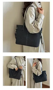 Detail of grey denim tote bag showing contrast stitching and golden hardware ring