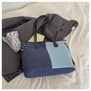 Detail of color-block canvas tote bag with black leather straps and gold metal rings