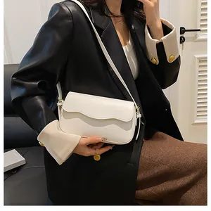 Détail du sac bandoulière blanc en cuir PU avec rabat ondulé et bandoulière fine