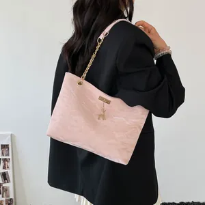 Detailed back view of pink wrinkled chain shoulder bag with golden deer pendant charm