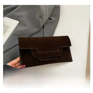 Detail shot of the unique three-tier geometric layered flap on this brown suede envelope bag