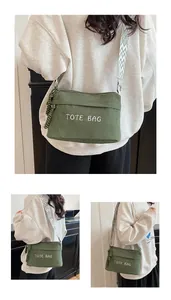 Detail der dunkelgrünen Cord-Tasche mit weißer Stickerei und Ethno-Schultergurt