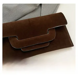 Detail of dark brown matte texture envelope clutch with unique asymmetrical flap design