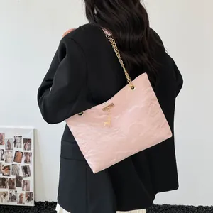 Pink textured leather shoulder bag featuring a gold chain and elegant deer pendant detail