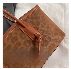 Dettaglio della borsa leopardata in pelle scamosciata marrone con logo a sbalzo