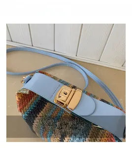 Detailed macro view of woven straw texture and light blue leather flap with gold metal lock