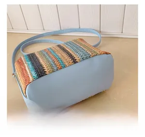 Close-up of contrast woven straw pattern and smooth blue leather on shoulder bag