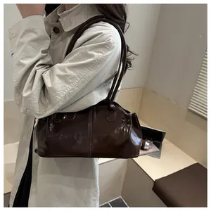 Detail der dunkelbraunen, glänzenden Leder-Einkaufstasche mit eleganten Schultergurten