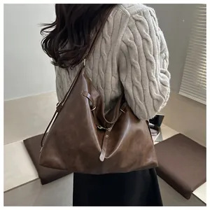 Detail view of large dark brown retro tote bag with aged matte leather texture