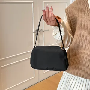 Chic black minimalist underarm bag with gold zipper and smooth nylon fabric finish