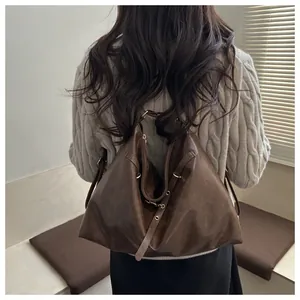 Detail of vintage large brown faux leather tote bag showing adjustable strap and gold hardware