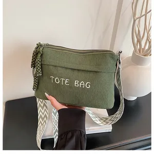 Detalle del bolso tote de pana verde militar con bordado y correa de hombro tejida